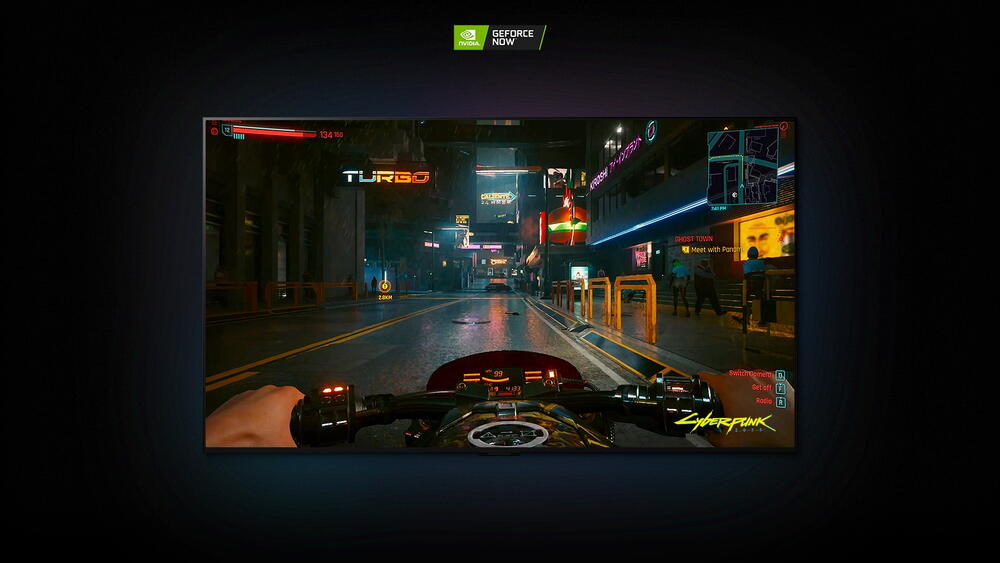 Ecranul LG OLED arata o scena din jocul Cyberpunk 2077 si un jucator care merge pe o motocicleta pe strazi cu neon.