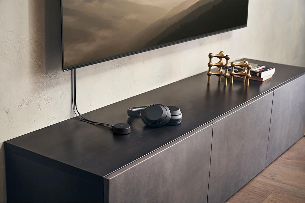 Imagine cu o pereche de casti Sony WH-CH720 negre pe un televizor, sub un televizor montat