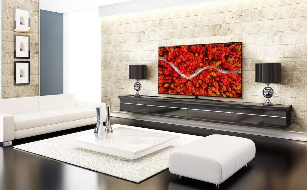 O cameră de zi de lux cu un televizor care afișează o vedere aeriană a pădurii de culoare roșie.