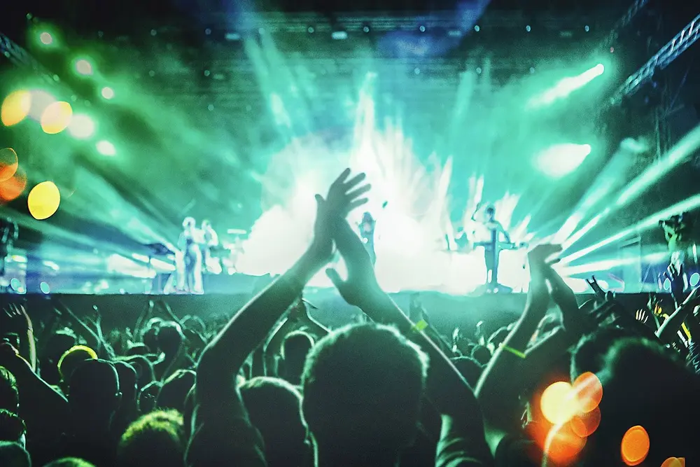 Imagine cu un concert de muzica live, cu mai multi oameni aplaudand, cu lumina albastra si verde