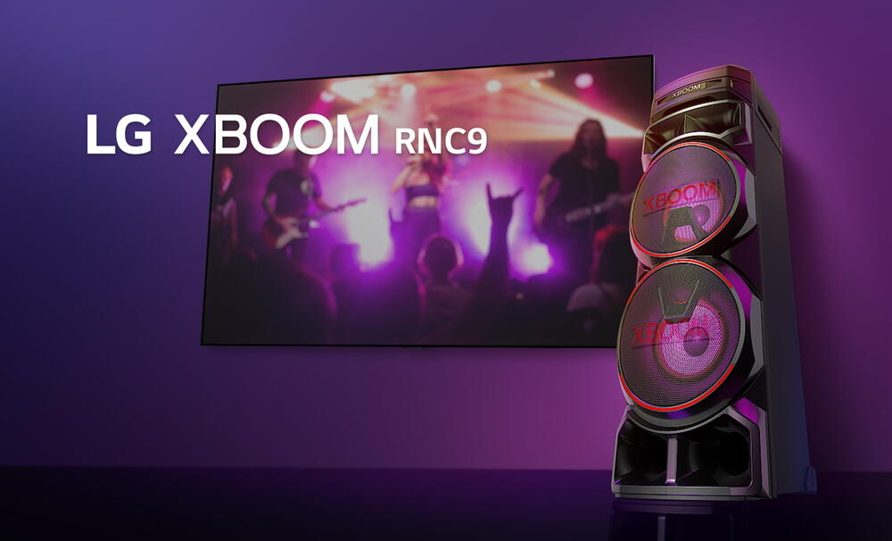 O vedere de jos a lateralei drepte a LG XBOOM RNC9 pe un fundal violet. Luminile XBOOM sunt, de asemenea, violet. Si un ecran TV afiseaza o scena de concert.