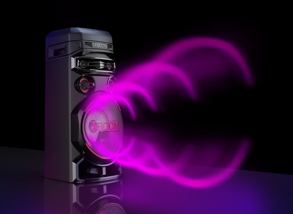 LG XBOOM RNC7 cu partea stanga inainte, pe un fundal negru. Grafica circulara de sunet violet iese din woofere.