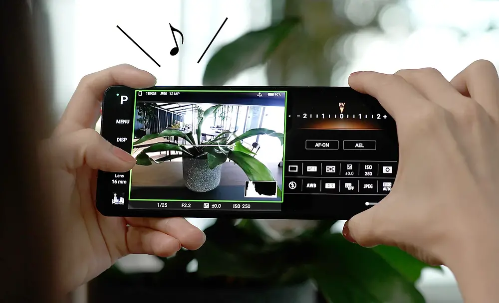 Imagine cu o persoana facand o fotografie cu Photography Pro pe Xperia 5 V cu o nota muzicala si linii deasupra, indicand sunetul