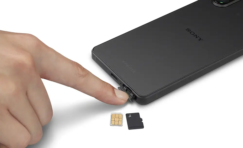 Imagine cu o persoana care deschide tavita SIM de pe un Xperia 5 V, cu doua cartele SIM alaturi